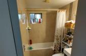 •	Amplio dormitorio principal (matrimonial) con closet fijo incrustado, alfombrado, muros de hormigón y tabiquería, buena iluminación natural, con vista al antejardín, baño privado cubierto de cerámica paredes y suelo, ducha y excelente lavamanos amoblado,  finas terminaciones en toda la habitación.